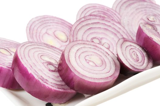 Dish with chopped red onion circles. Isolated on white.