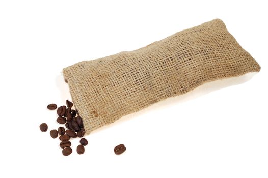 Roasted coffee beans scattered on rough sackcloth