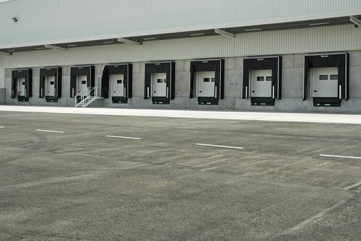 The loading area of a industrial warehouse with several loading bays and a truck.