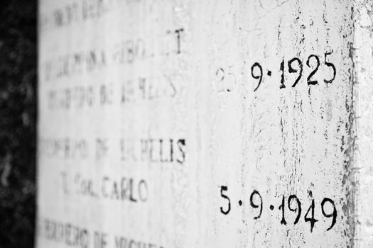 Old tombstone in Italian cemetery with birth and death dates