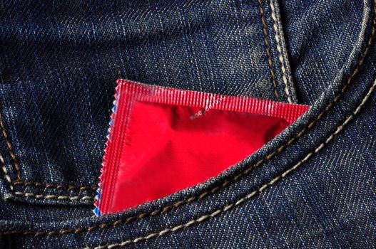 A red condom inside a jeans pocket