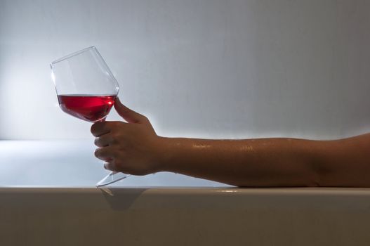 Woman taking a bath and relaxing with a glass of wine