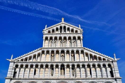 The Duomo of Pisa with a blue sky behind.