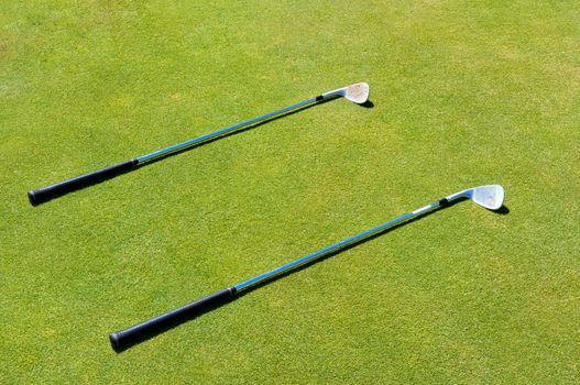 Two golf club lying on the grass