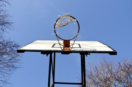 Basketball board with an old tattered basketball net on the hoop