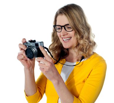Smiling caucasian photographer looking at her camera