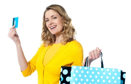 Attractive woman holding cerdit-card with shopping bags smiling against white background