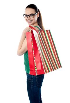 Side view of woman holding shopping bags against white background