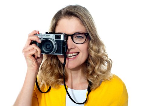 Beautiful young girl with camera, capturing an image