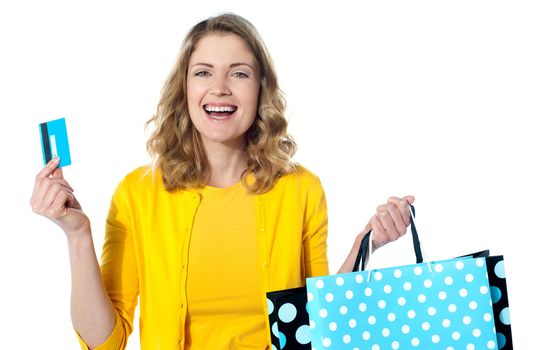 Happy shopaholic female laughing. Holidng credit-card and shopping bags