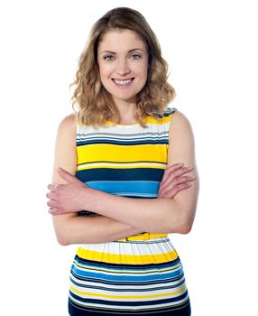 Portrait of an attractive young woman standing with her hands folded against white background