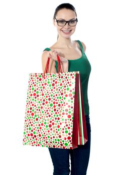 Glamorous young girl carrying shopping bags isolated over white