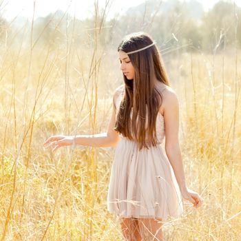 Asian indian woman walking in golden dried grass field