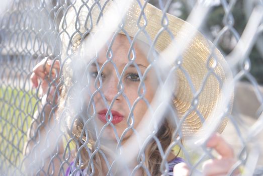 A woman is confined to the chain link fence.