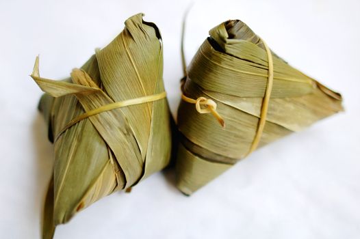 A pair of glutinous rice dumplings on a white background