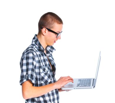 Seated teenager using a laptop. Isolated on white background