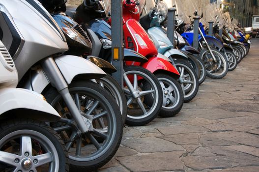 Line of different motocycles on stone road