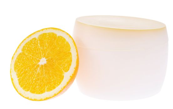 Container for cream and slice of juicy orange isolated on white background