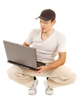 Handsome casual sitting man with open laptop and is looking on a screen on white background