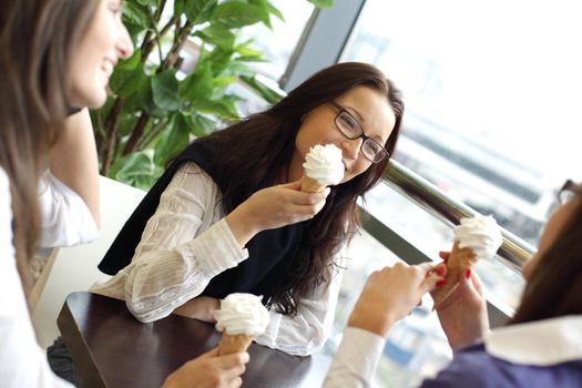 women on foreground licking ice cream 