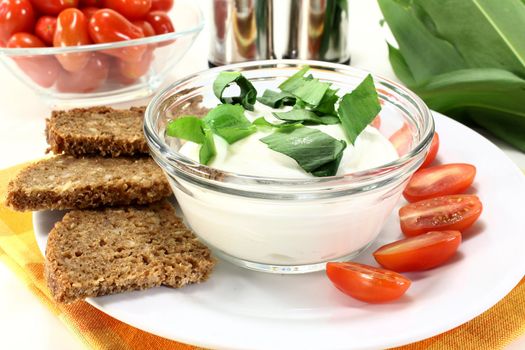 a bowl of wild garlic curd with bread and tomato