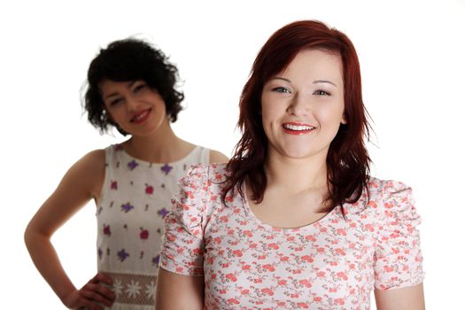 Two happy woman posing over white background.