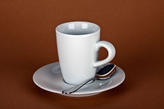 white coffe cup with coffe beans and a silver spoon