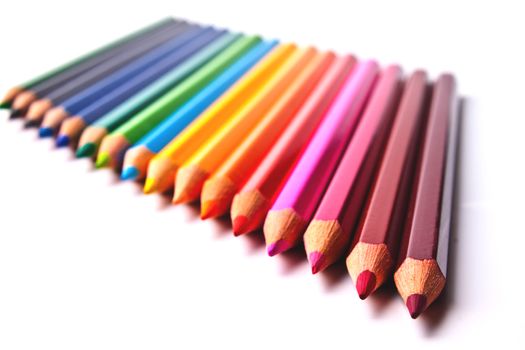 a bunch of colored pencils on a light background