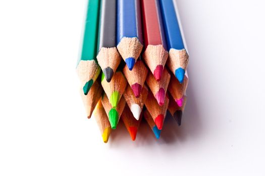 a bunch of colored pencils on a light background