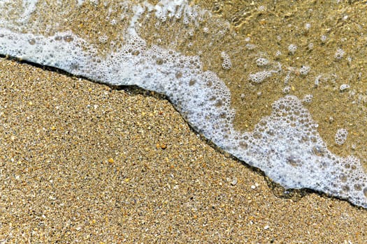 sea ​​foam incident on the beach in the background