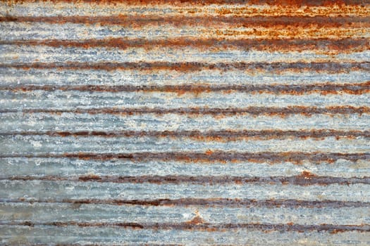 Fragment of old ribbed metal plate covered with several layers of shelled paint