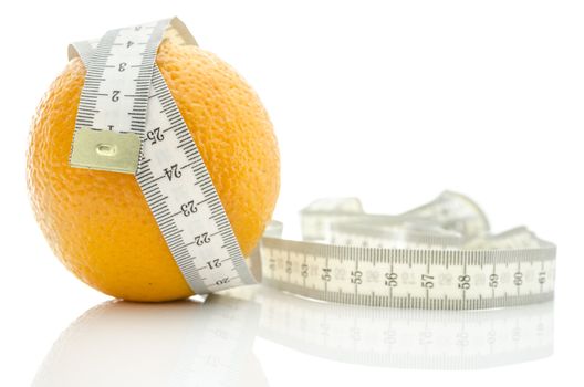 Orange fruit wrapped with white measuring tape. Isolated over white background.