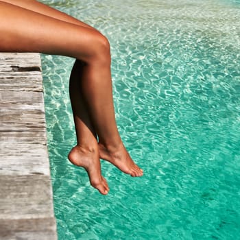 Woman's legs at beach jetty