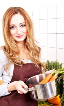 young beautiful housewife is cooking with fresh vegetables