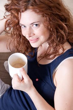 young beautiful woman with red hair and a cup of coffee