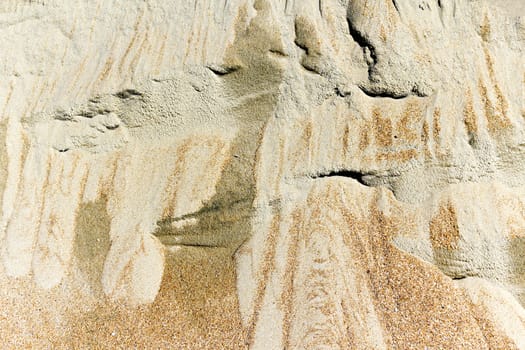 	
patterns of erosion of sand in the background