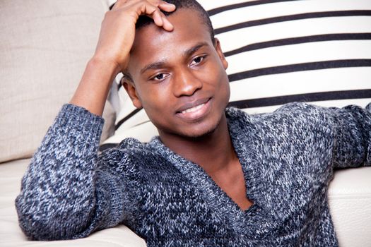 dark-skinned man sitting on the floor in front of the couch