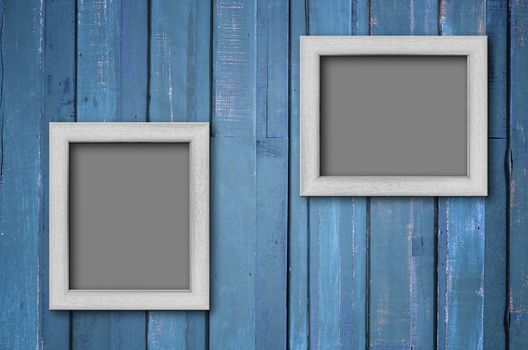Two white wood picture frame on Blue color paint plank wall for background