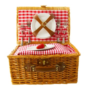 Wooden basket for picnic with plates and a strawberry isolated over white