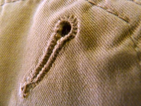 button hole in the fabric of some trousers