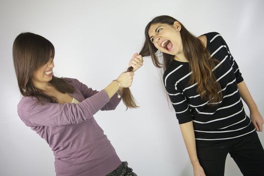 Girl pulling hard the hair to another girl that shouts