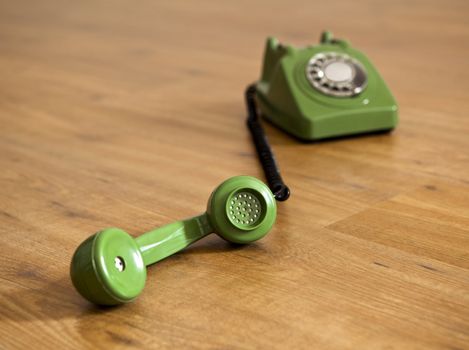 Vintage green phone over a wood floor