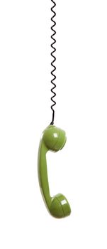 Handset piece from an old phone suspended by the phone cord, isolated on white background