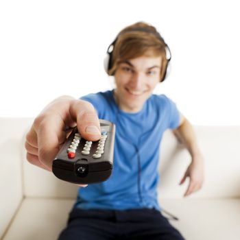 Young man sitting on the couch using a remote control
