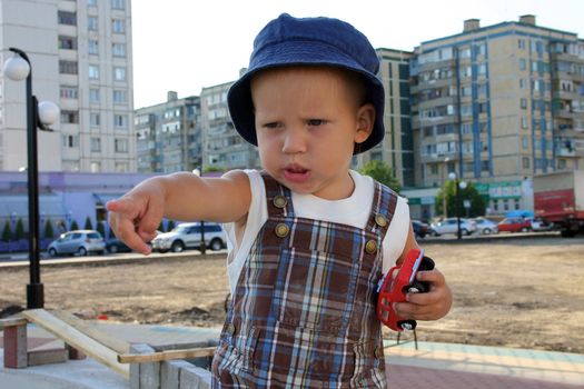 baby boy playing with toy auto in sand box