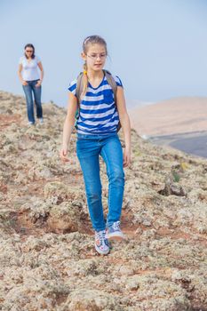 Cute girl and her mother hiking in the cross-country