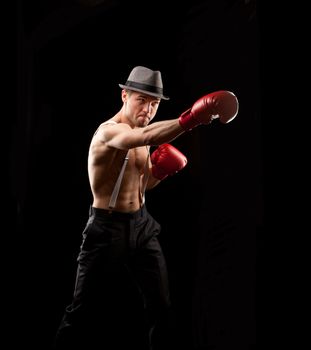 boxer in the hat on with suspenders over black