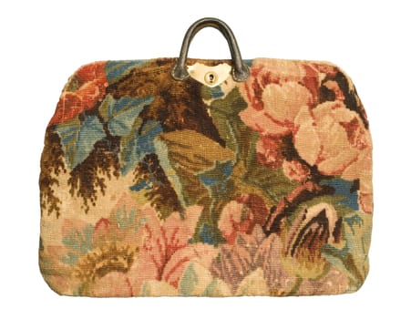 An antique carpetbag with a flower pattern isolated against a white background