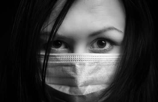 Girl in protective mask against dark background