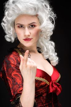 Young woman in baroque custome against dark background